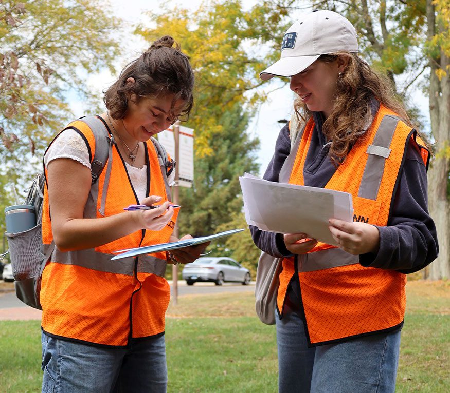 ECorps students reviewing notes near a stormdrain.